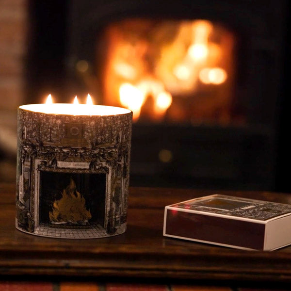 Home For Christmas three wick candle lit by the fire, with the Home For Christmas matches beside it